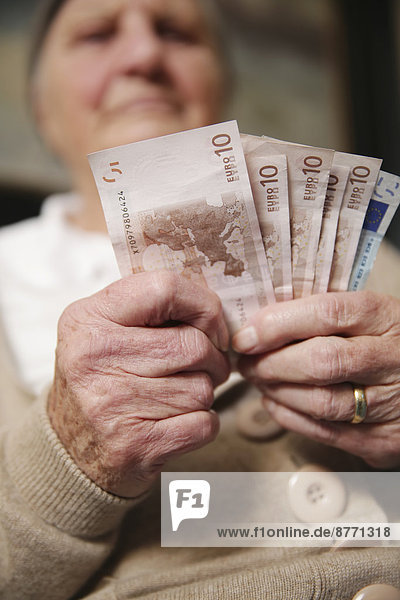 Senior woman holding euro notes