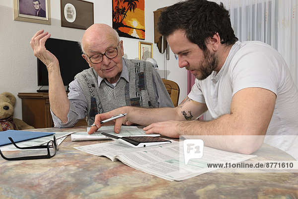 Grandson helping his grandfather by making tax declaration