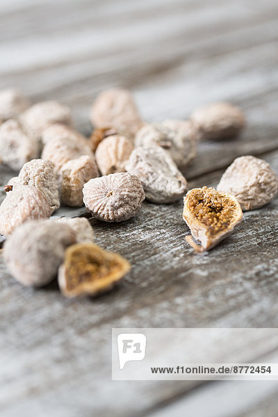 Dried figs coated with spelt flour on wooden table