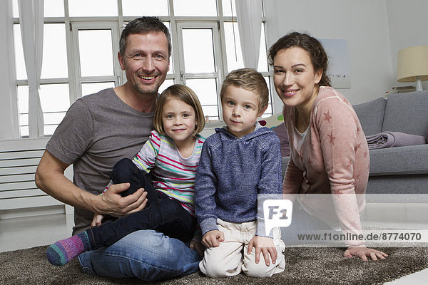 Happy family of four in living room