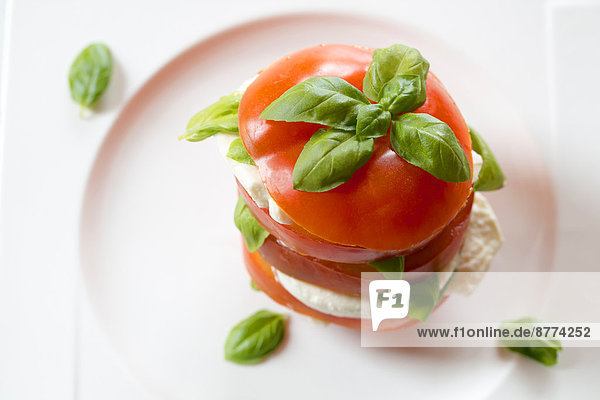 Geschnittene Tomaten  Mozzarella und Basilikum auf dem Teller