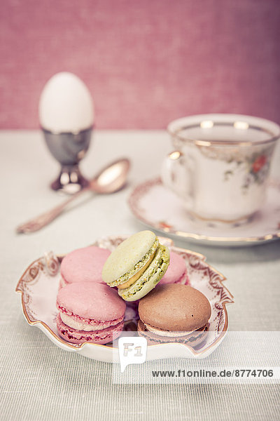 Easter installation with cup of coffee,  egg,  and bowl of macarons