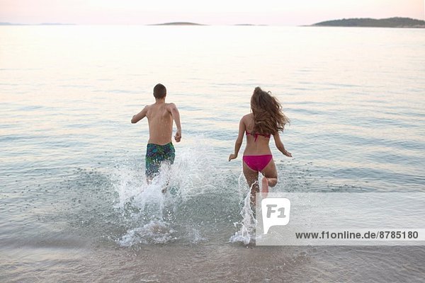 Junges Paar  das zusammen ins Meer läuft  Orebic  Kroatien
