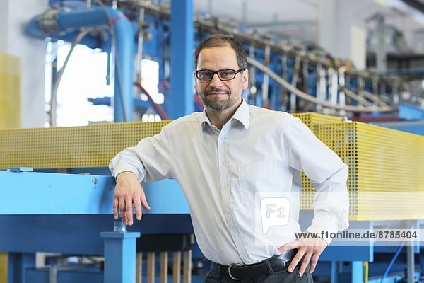 Portrait of manager and industrial machinery