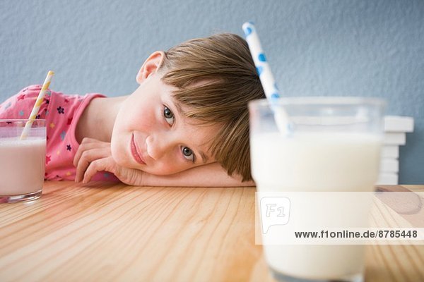 Mädchen schaut auf ein Glas Milch