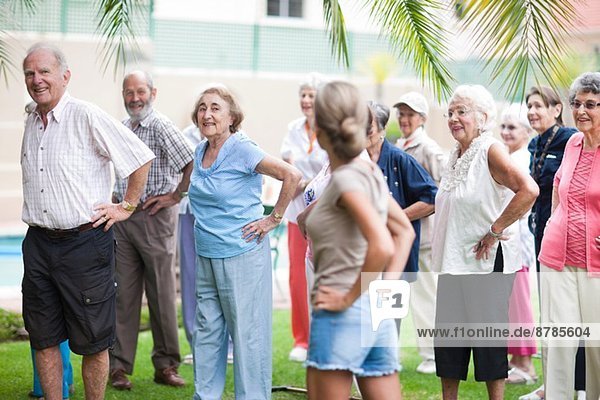 Large group of seniors exercising in retirement villa garden