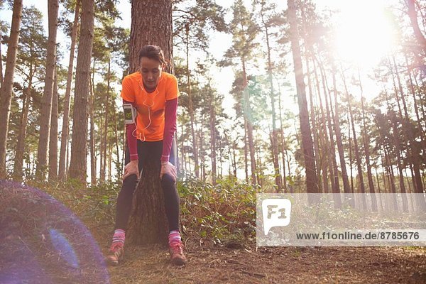 Mature woman runner taking a break in a forest