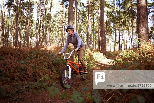Boy riding his BMX in forest