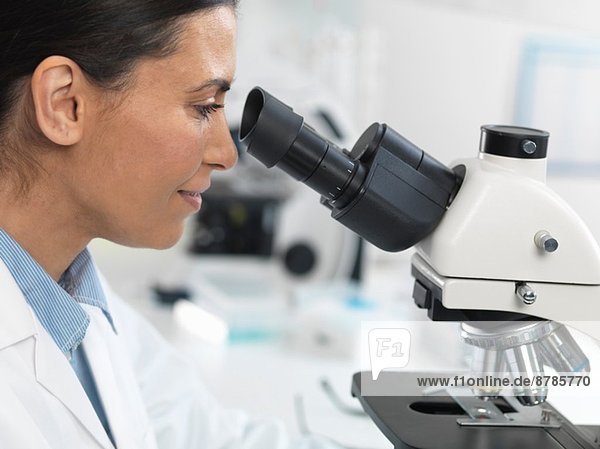 Wissenschaftlerin beim Betrachten von Objektträgern für klinische Tests im Labor