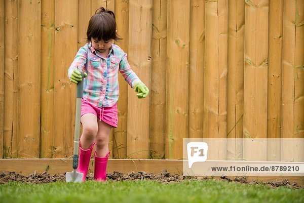 Junges Mädchen beim Erdgraben im Garten