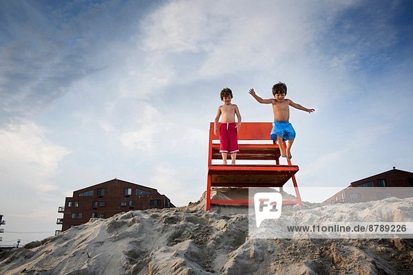 Zwei Jungen springen vom roten Brett  Long Beach  New York State  USA