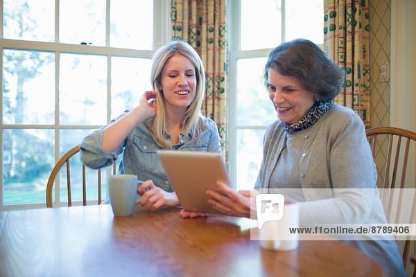 Seniorin und Enkelin beim Betrachten des digitalen Tabletts