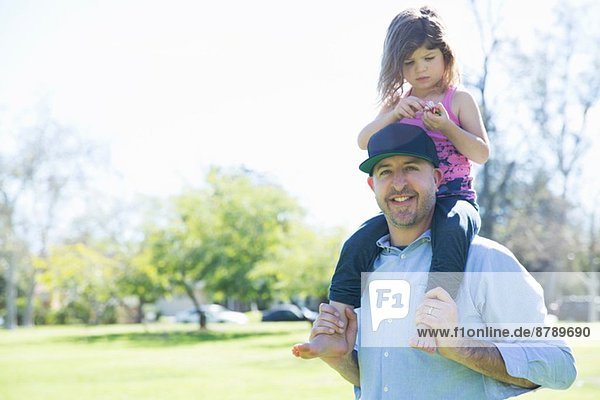 Porträt eines erwachsenen Mannes mit junger Tochter auf den Schultern