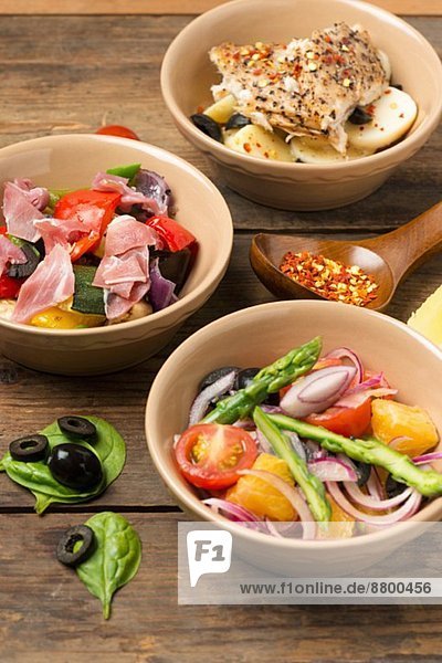 Drei verschiedene Salate (Spargelsalat  Gemüsesalat mit Rohschinken  Kartoffelsalat mit Fisch)