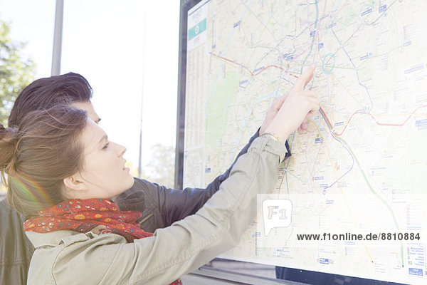 Touristenpaar schaut sich den Stadtplan an der Touristeninformation an.