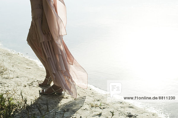 Frau im Kleid  die am Ufer entlang läuft  niedriger Abschnitt