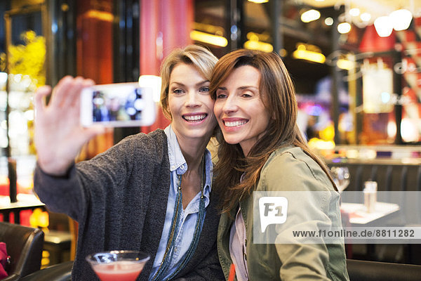 Women in bar taking self-portrait with photophone