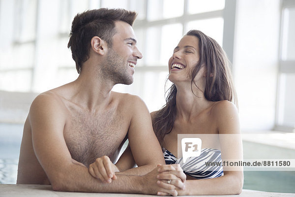 Couple relaxing together in indoor swimming pool