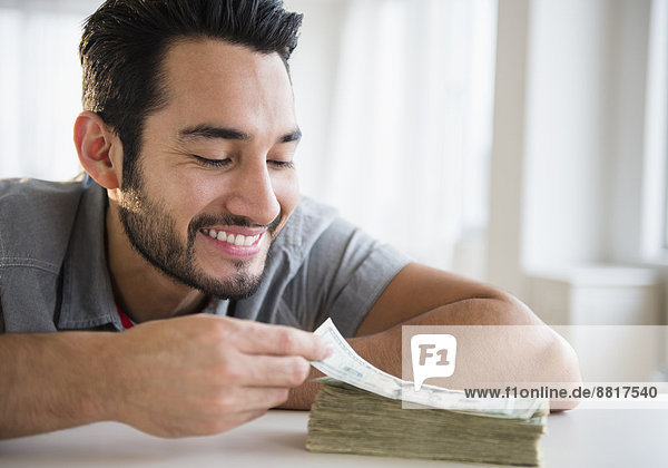 Mixed race man counting stack of money