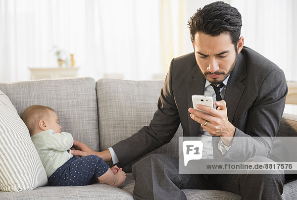 sitzend  benutzen  Menschlicher Vater  Telefon  Handy  Baby