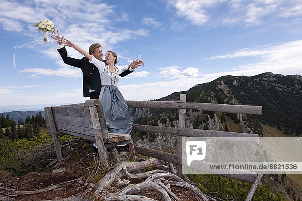 Wedding couple on a mountain throwing the bridal bouquet  Mt Spitzplaneck  Almtal Valley  Upper Austria  Austria
