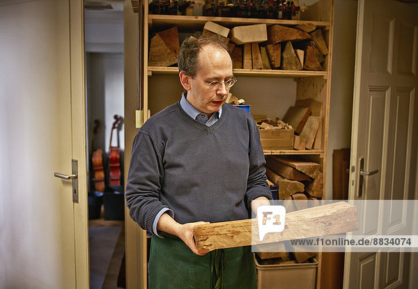 Geigenbauer bei der Auswahl des Holzmaterials