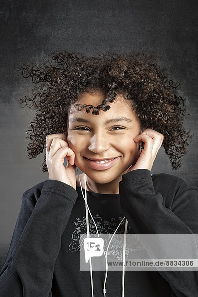 Porträt eines lächelnden jungen Mädchens beim Musikhören