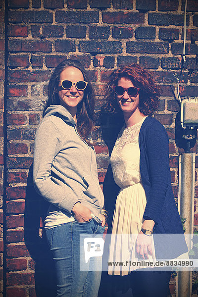 Zwei junge lächelnde Frauen mit Sonnenbrille