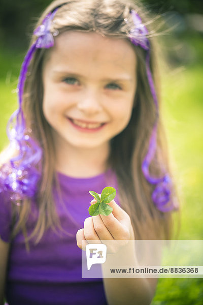 Kleines Mädchen mit vierblättrigem Kleeblatt