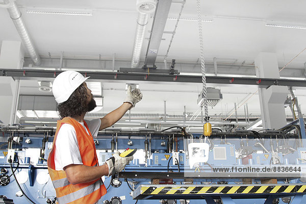 Arbeiter mit Schutzhelm in einer Fabrikhalle