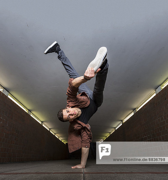 Junger Breakdancer mit Handstand in der Unterführung