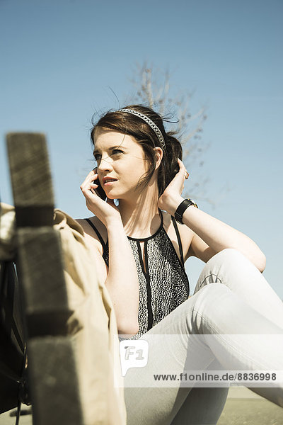 Portrait of young woman telephoning with smartphone