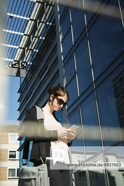 Portrait of young business woman using smartphone