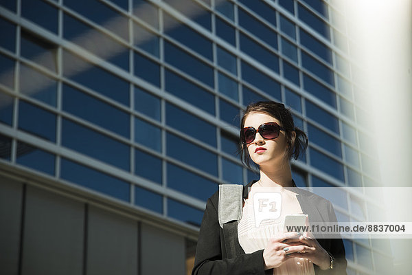 Portrait of young business woman with smartphone