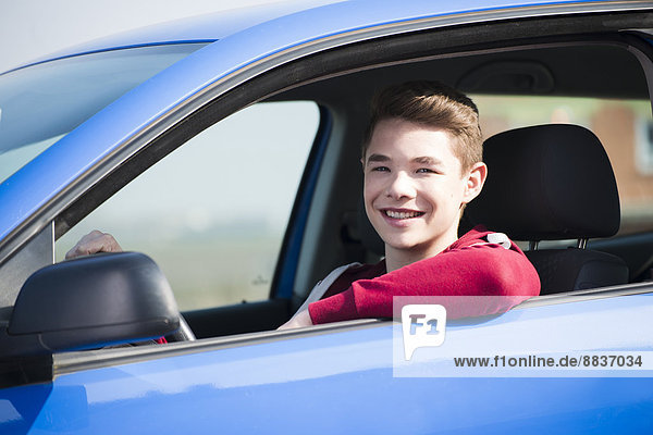 Teenager sitting in car  partial view