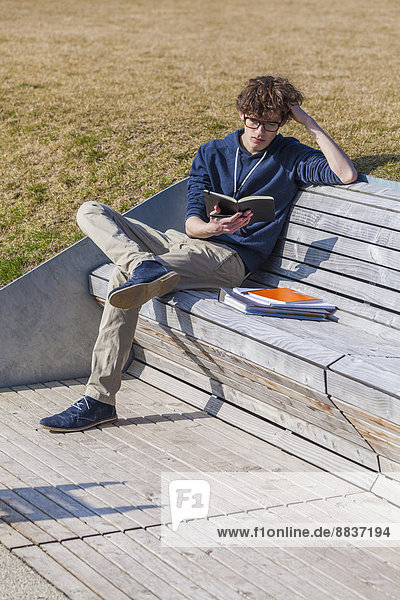 Teenage boy sitting on bench  learning