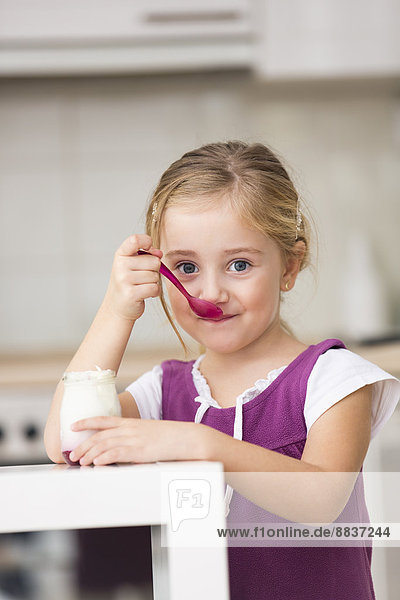 Porträt eines kleinen Mädchens beim Joghurtessen