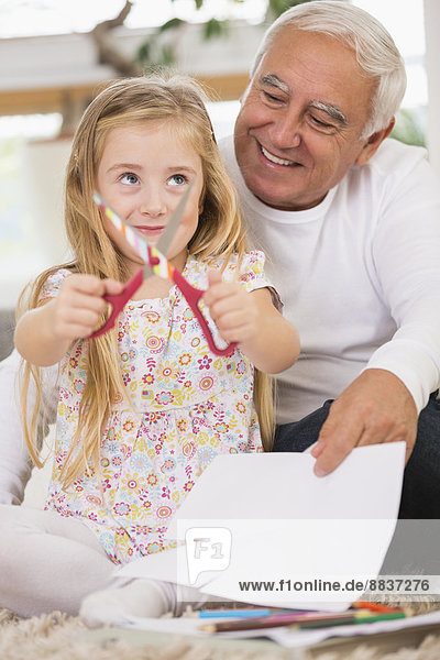 Senior man and granddaughter tinkering at home