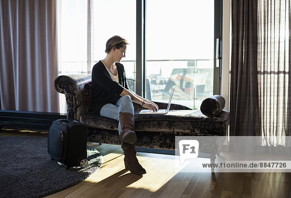 Geschäftsfrau mit Laptop im Hotelzimmer
