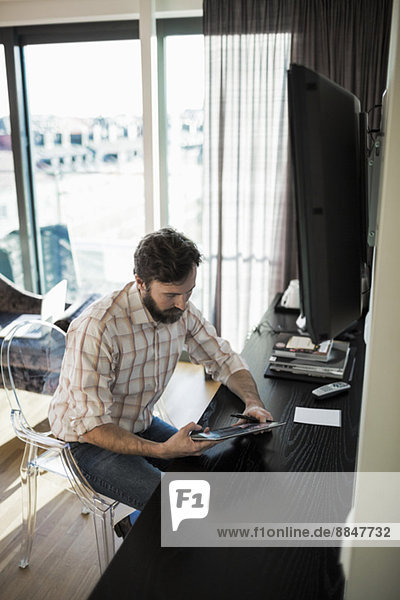 Businessman using digital tablet in hotel room