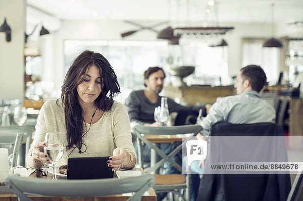 Geschäftsfrau mit digitalem Tablett im Restaurant