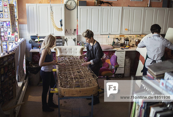 Arbeiterinnen machen gemeinsam in der Werkstatt Chaiselongue
