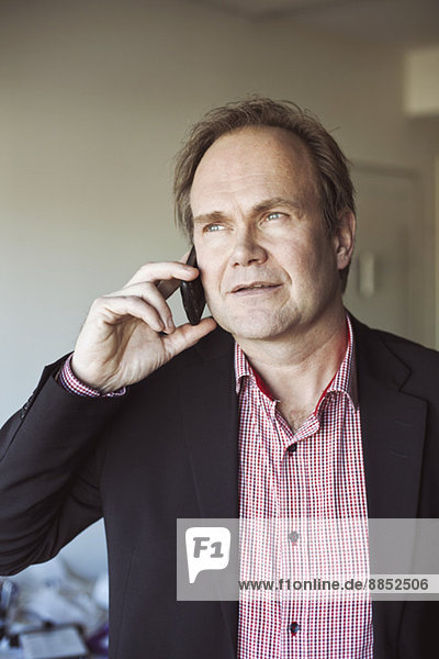 Erwachsener Mann mit Handy zu Hause