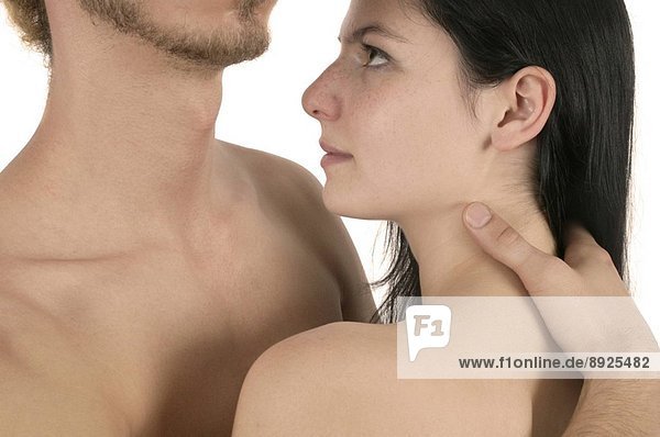 In love  a young nude man and woman in romantic embrace against a white background. The man has a designer_style beard and the woman has long dark hair.