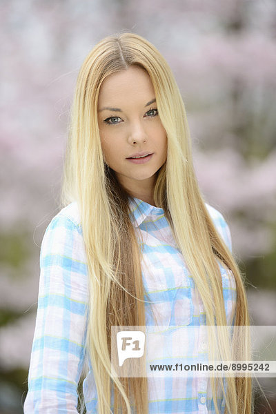 Junge blonde Frau in einem Park im Frühling
