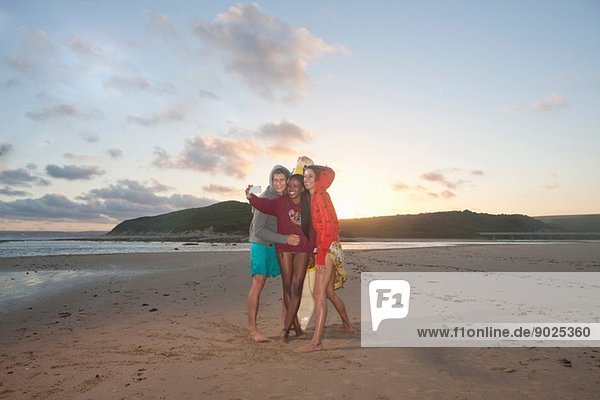 Freunde am Strand beim Selbstporträtfotografieren
