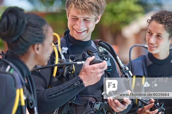 Scuba diving instructor demonstrating oxygen mask to female pupils