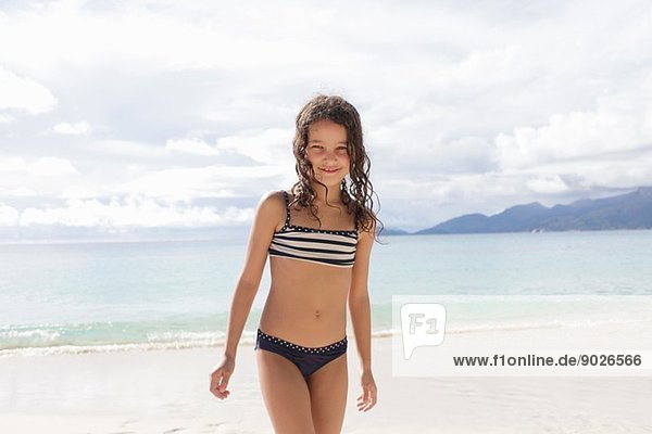 Mädchen steht am Strand der Seychellen