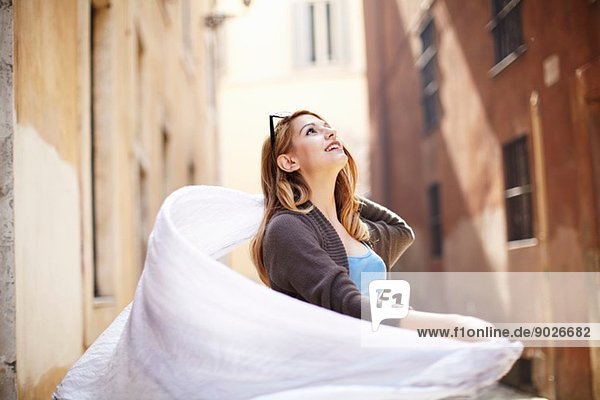 Young woman swirling her scarf on street  Rome  Italy