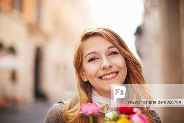 Lächelnde junge Frau mit einem Blumenstrauß